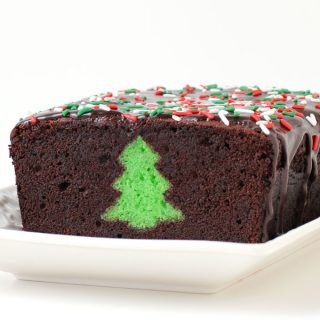 A chocolate thin mint Peek-a-Boo Christmas pound cake is cut open to reveal a green Christmas tree hiding inside.