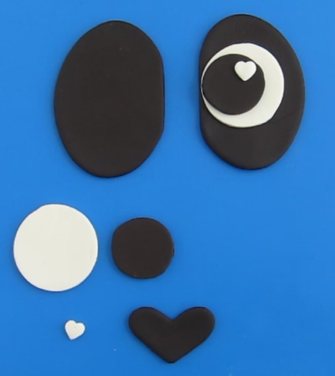 pieces cut out of white and black modeling chocolate to make the panda bear's eyes and nose for on the cake