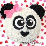 cute panda bear cake with a pink bow is decorated with frosting and modeling chocolate
