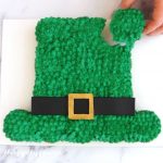 pull-apart leprechaun hat cupcake cake with someone pulling a cupcake from the cake