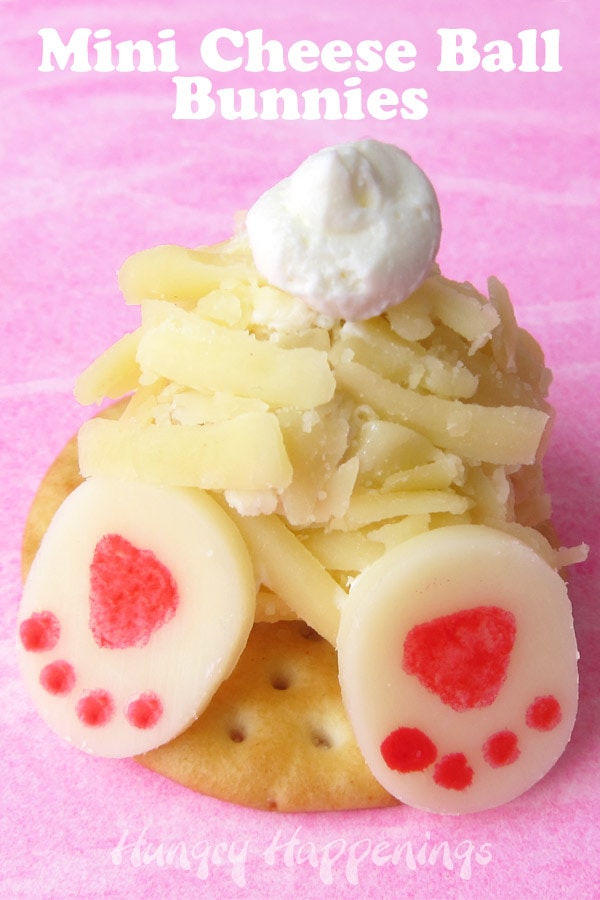 close-up image of one mini cheese ball bunny butt with a fluffy cream cheese tail and two floppy feet made out of white cheddar cheese and pink food coloring