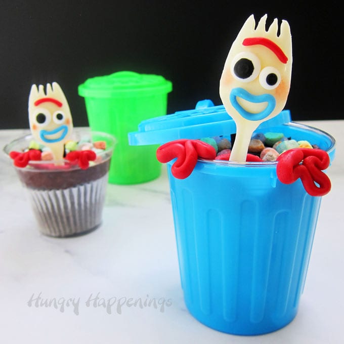 Forky Cupcakes are decorated with white chocolate forks that look like Forky and are served in plastic garbage cans.