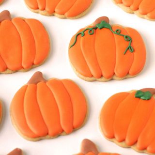 Pumpkin shaped pumpkin spiced cut-out cookies decorated with maple infused royal icing.