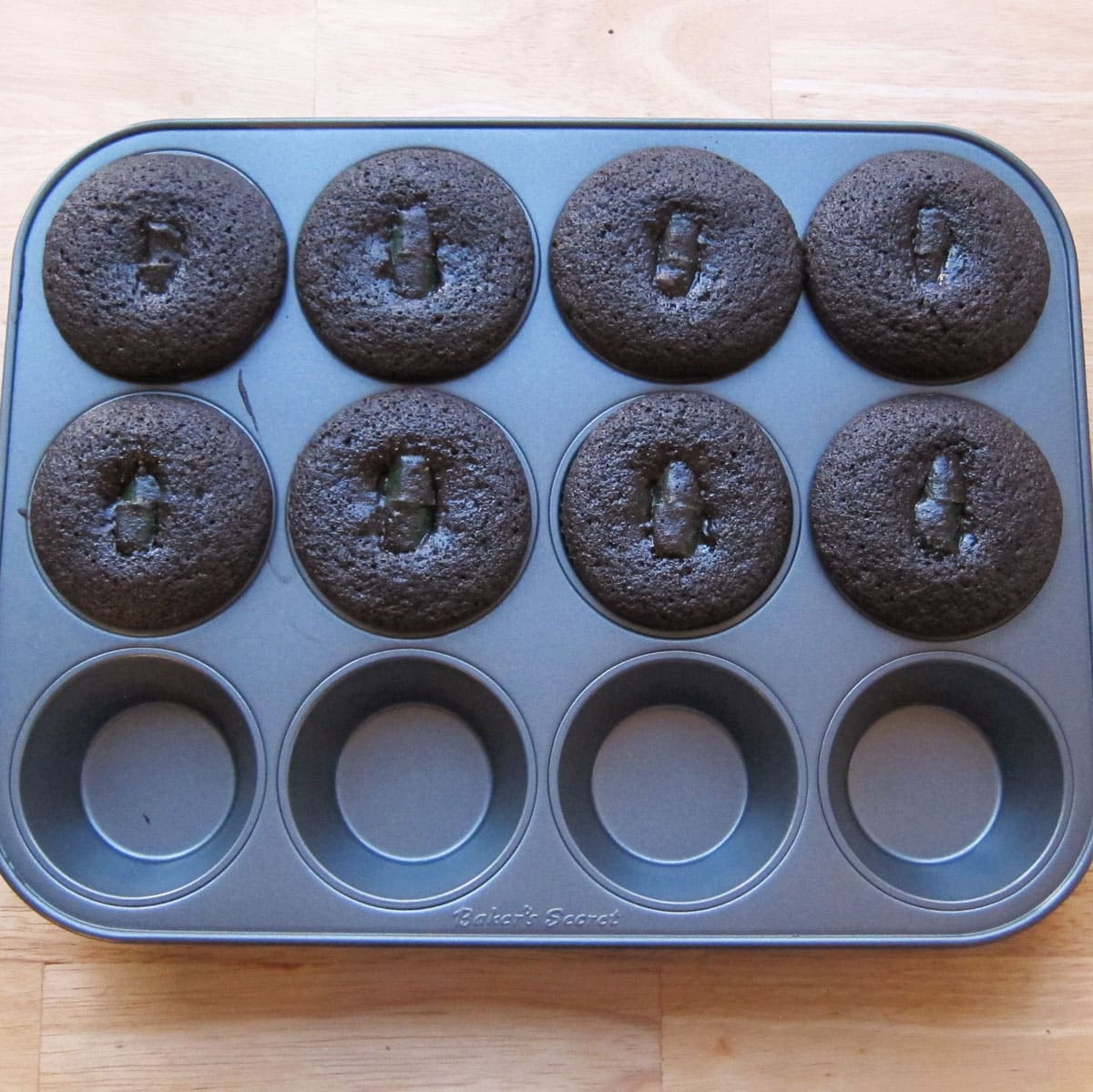 baked cheesecake stuffed chocolate cupcakes in a non-stick cupcake pan. 