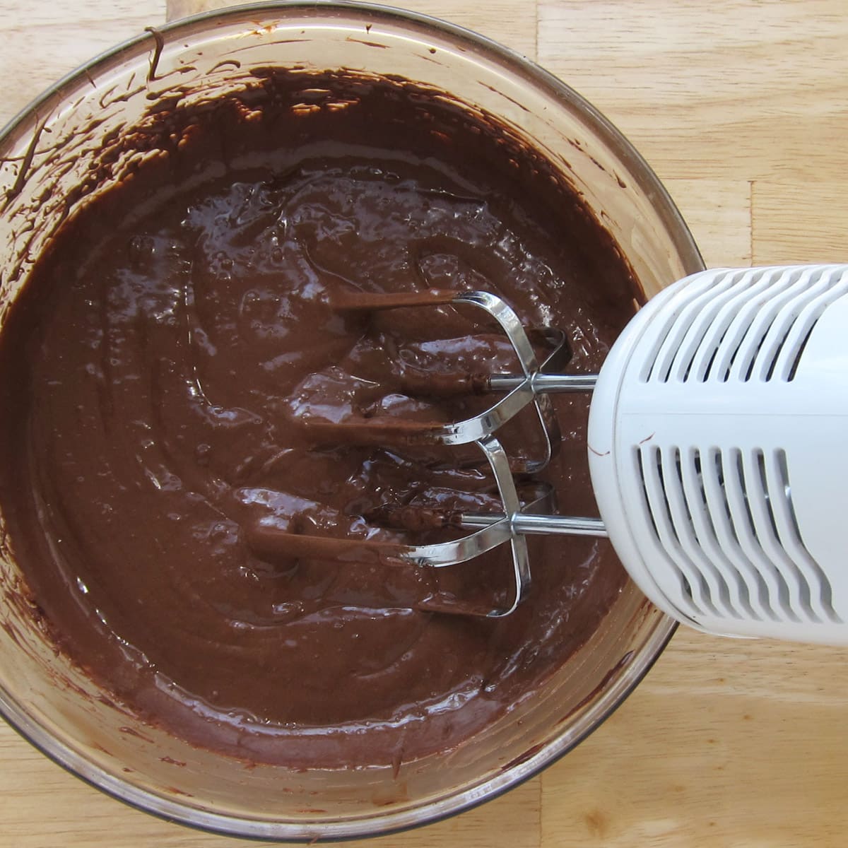 beating chocolate ganache using a hand-held mixer.