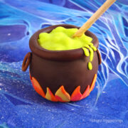 chocolate caramel apple cauldron decorated with modeling chocolate flames and magical potion.