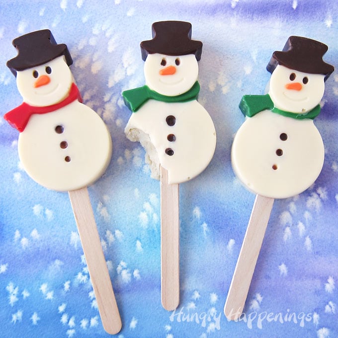 hand-painted Snowman Cakesicles on a snowy watercolor background