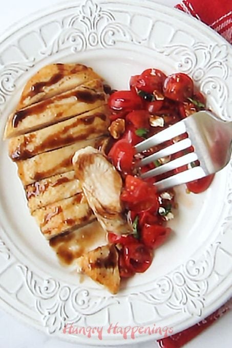 Slice a chicken breast then plate it next to diced grape tomatoes in a heart shape then add a sprinkling of feta cheese, basil, and balsamic glaze. 