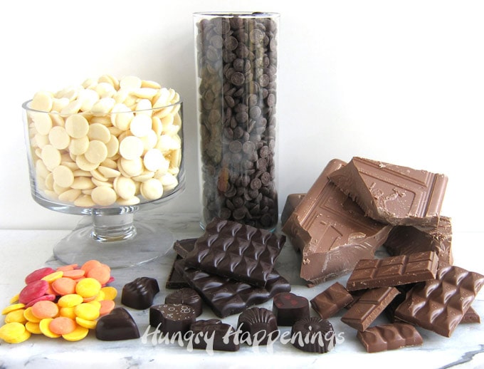 chocolate bars, blocks, wafers, and shapes on a white and black marble slab