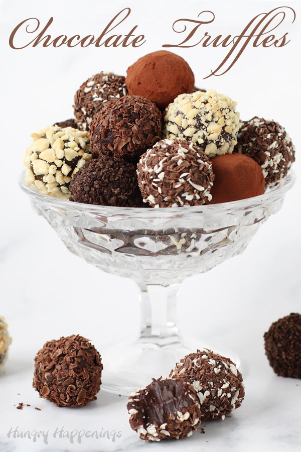 Beautifully chocolate truffles displayed in a candy dish are coated in chocolate shavings, cocoa powder, chopped nuts, and cookie crumbs.