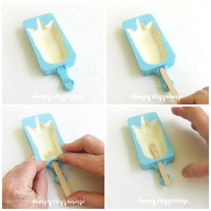 Insert a wooden popsicle stick into the wet white chocolate in the silicone unicorn mold. 
