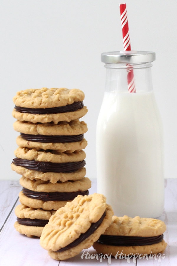 Chocolate ganache filled peanut butter sandwich cookies with a bottle of milk.