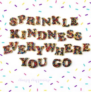 Sprinkle Kindness Everywhere You Go Cookies surrounded by colorful sprinkles.