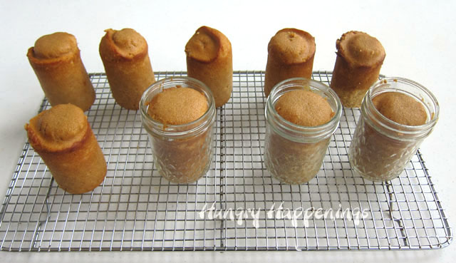 root beer cakes baked in mason jars are set on a cooling rack