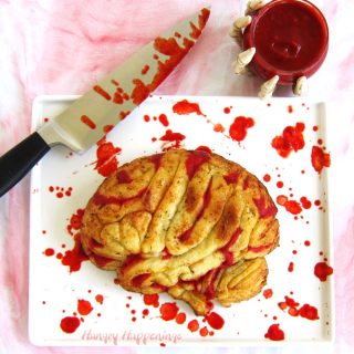 Stuffed Pizza Brain served with bloody marinara sauce on a blood stained white platter and a blood dripping knife.