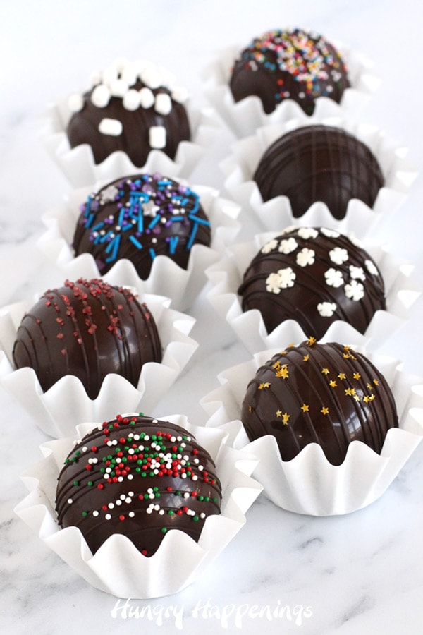 Beautifully decorated hot chocolate bombs are topped with sprinkle, marshmallows, and edible glitter.