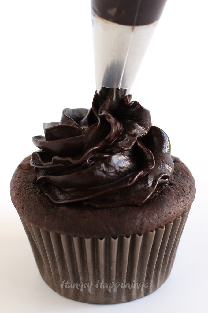 Pipe chocolate ganache over top of a chocolate cupcake.