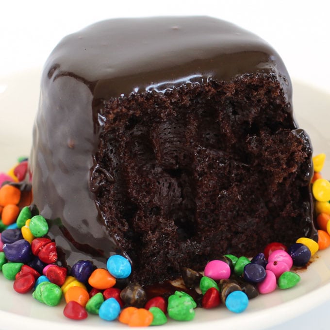 Chocolate Glaze over a chocolate cupcake served with candy coated chocolate chip sprinkles.