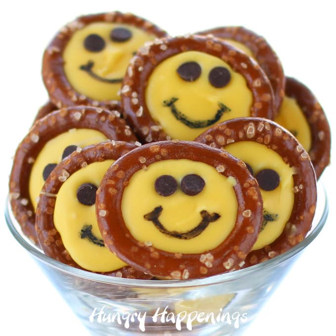 Bright yellow smiley face pretzels made using yellow candy melts or white chocolate.