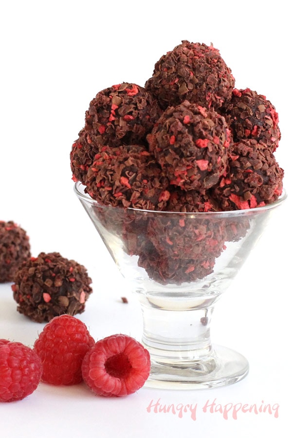 Homemade chocolate raspberry truffles are coated in dark chocolate shavings and bits of freeze-dried raspberries.