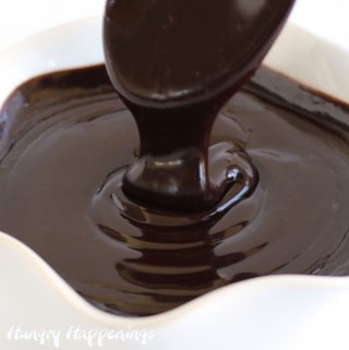 Chocolate ganache dripping off a spoon into a bowl.