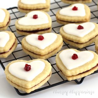 heart-shaped empire cookies are filled with raspberry preserves and are topped with a sweet glaze
