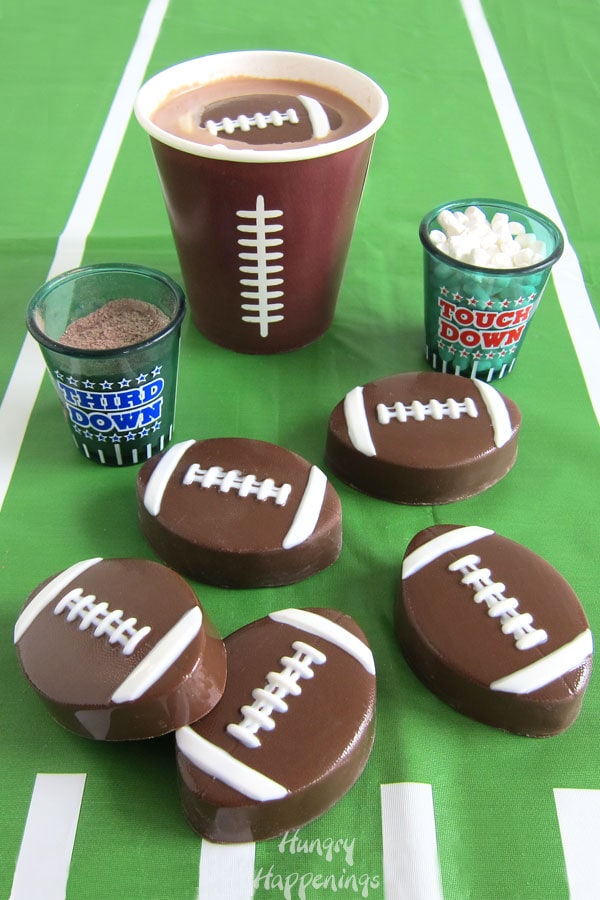 Football-themed hot chocolate bombs melt into a cup of creamy hot chocolate