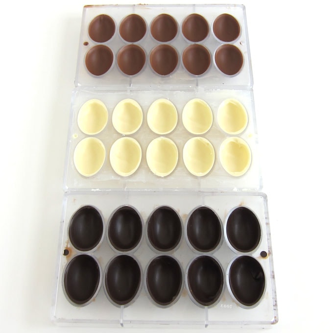 Milk chocolate egg shells, white chocolate egg shells, and dark chocolate egg shells made using polycarbonate egg molds.