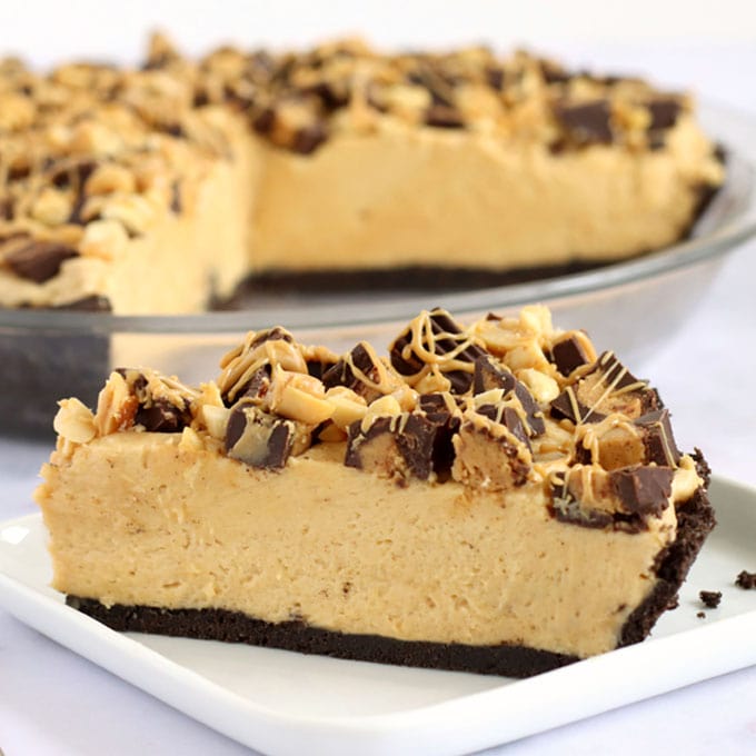 No-bake peanut butter pie on a chocolate cookie crust and topped with Reese's cups and peanuts.
