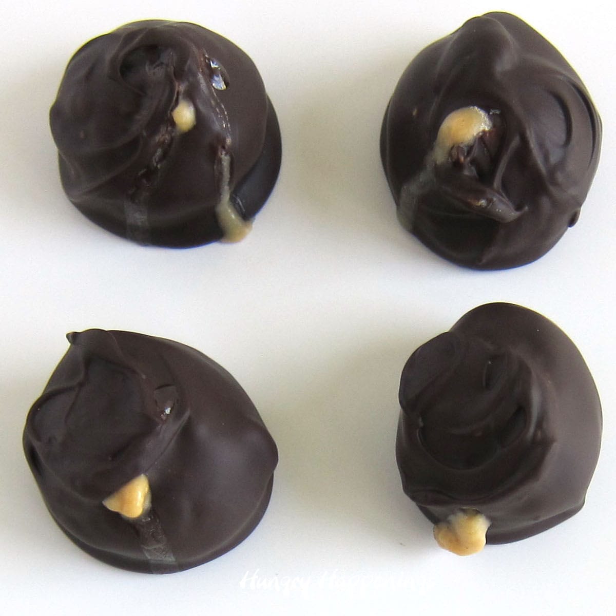 greasy peanut butter balls with filling oozing out of the chocolate