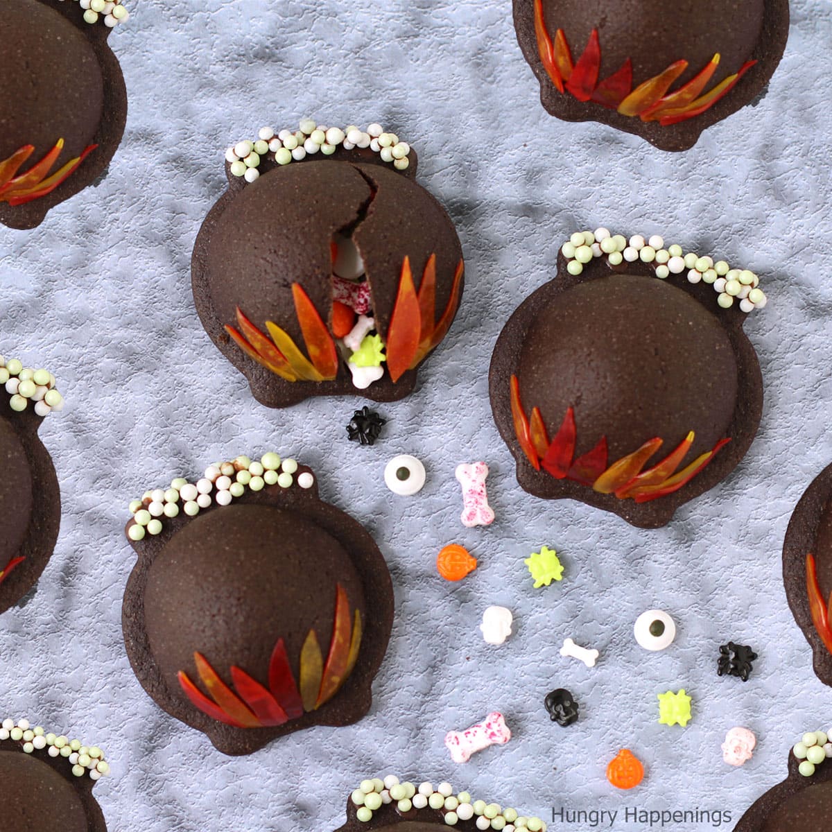 chocolate cauldron cookies filled with candy and decorated with fruit roll flames.