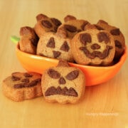 peanut butter pumpkin cookies decorated like Jack-O-Lanterns.