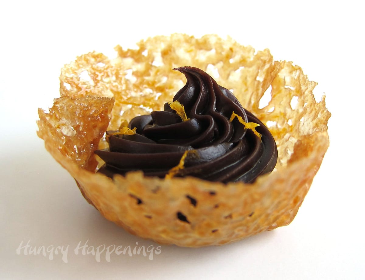 Orange lace cookie cups filled with orange chocolate ganache topped with orange zest. 