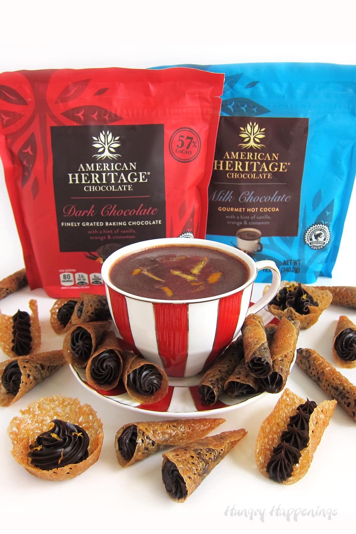 Orange tuile cookies filled with orange chocolate ganache arranged around a cup of American Heritage Hot Chocolate. 