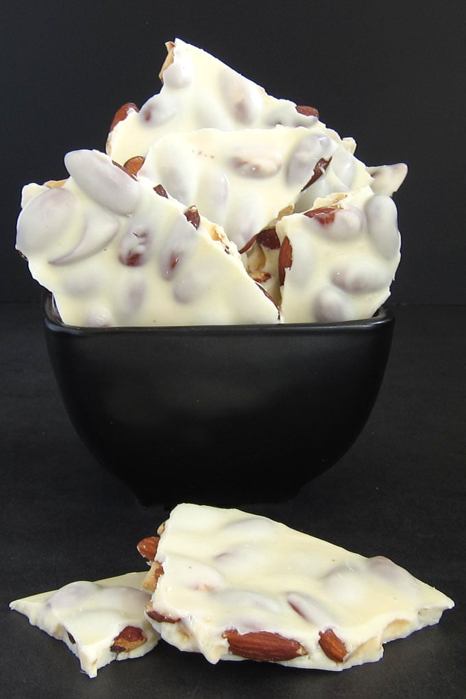White chocolate almond bark in a black bowl.