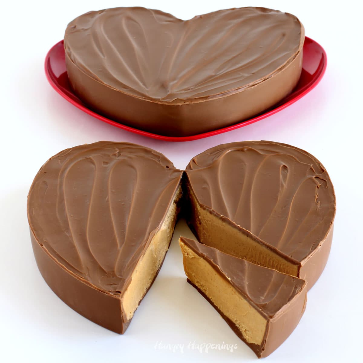 Two giant chocolate peanut butter cup hearts with one cut open showing the peanut butter fudge inside.