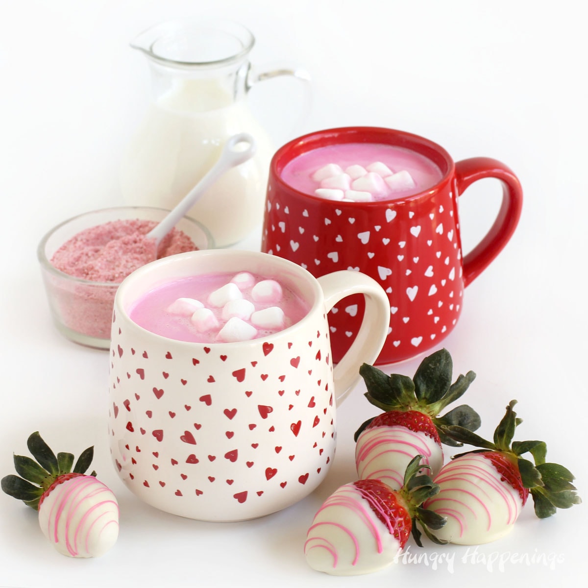 homemade strawberry hot cocoa mix, milk, strawberry hot chocolate in Valentine's Day mugs, and white chocolate dipped strawberries