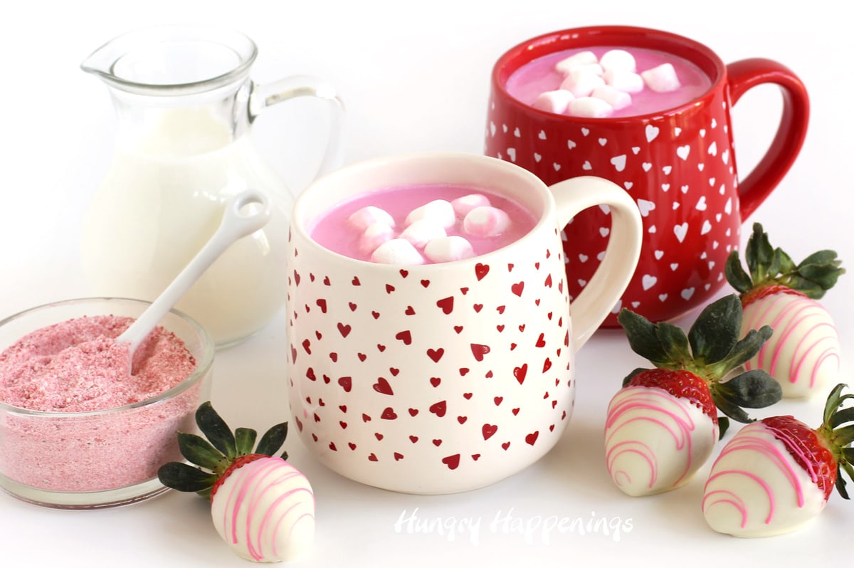 strawberry hot chocolate served in Valentine's Day coffee mugs with white chocolate dipped strawberries