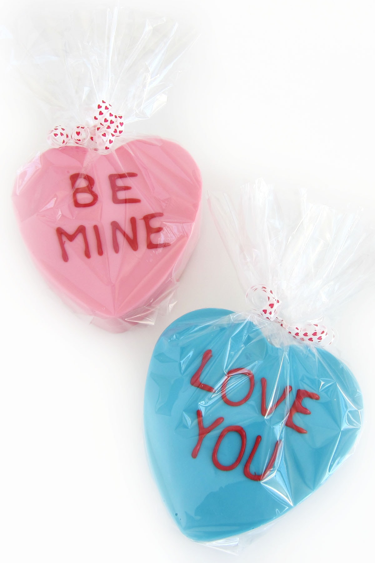 white chocolate breakable conversation hearts wrapped in clear cellophane tied with red heart ribbons