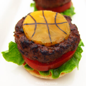 cheeseburger topped with a slice of cheddar cheese decorated to look like a basketball