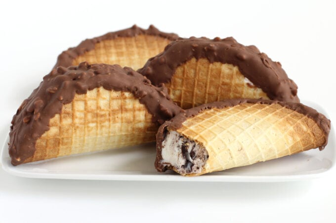 taco-shaped waffle cones filled with ice cream and topped with peanuts and milk chocolate