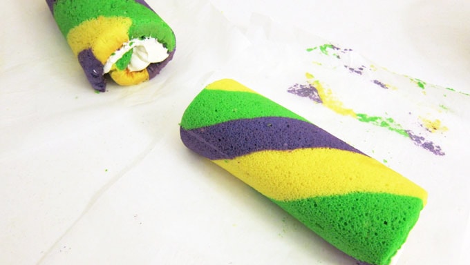 take the striped Mardi Gras cake roll out of the parchment paper roll