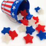 red, white, and blue gumdrop stars spilling out of a 4th of July pail