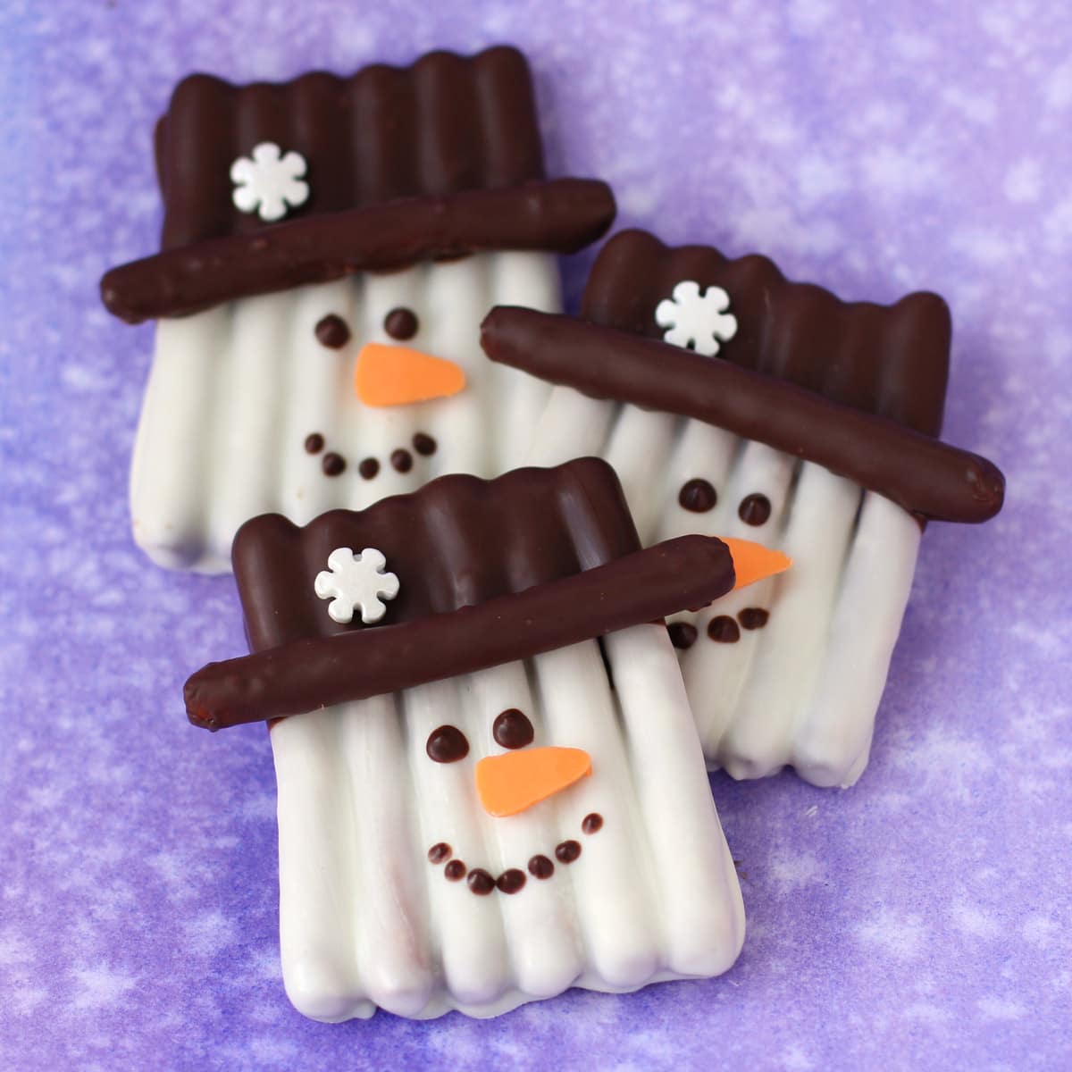 snowman pretzels made with pretzel sticks and candy melts.
