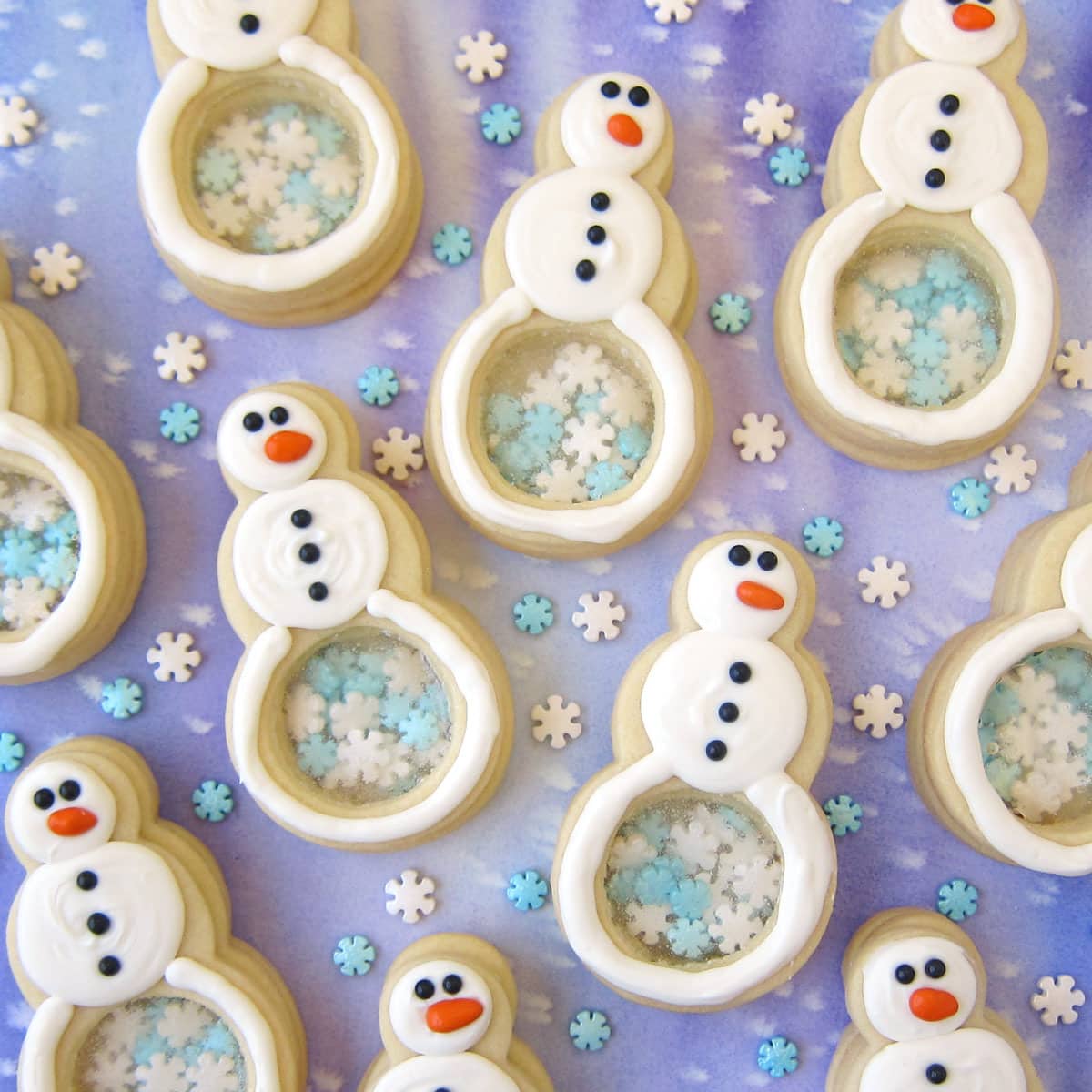 snowman cookies with a candy glass belly with snowflakes inside.
