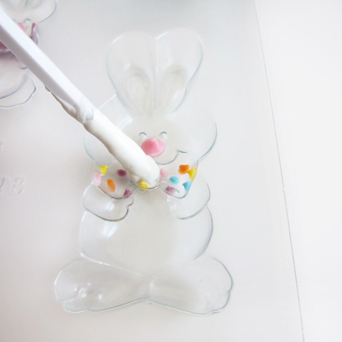 Painting white candy melts over polka dots in the bow tie bunny mold.