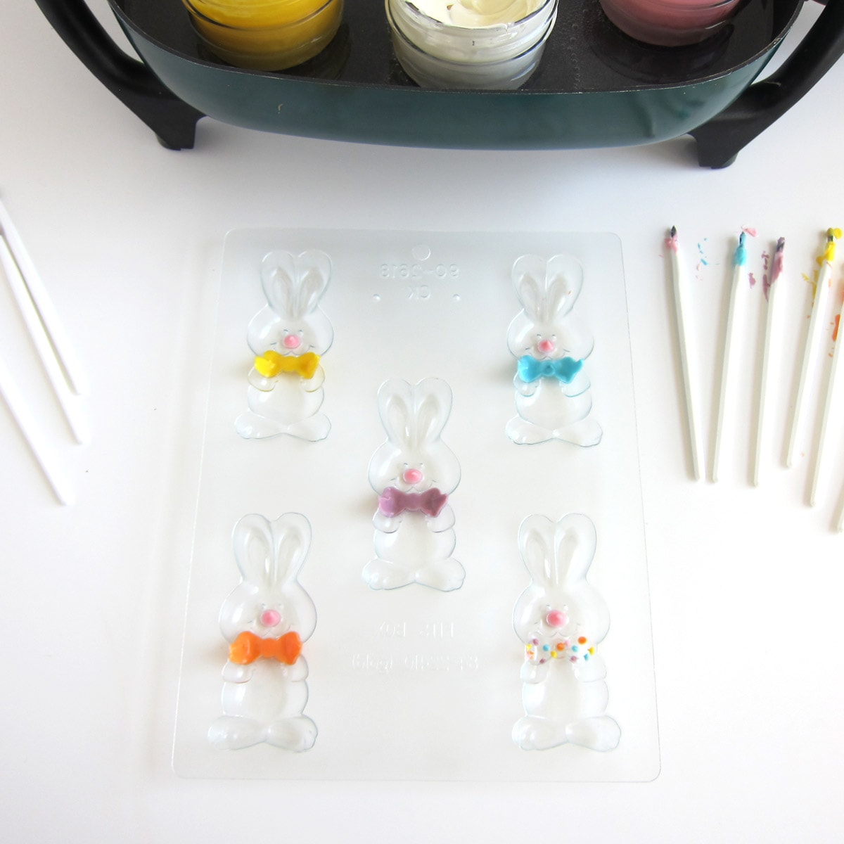 Bunny candy molds painted with pink noses and colorful bow ties.