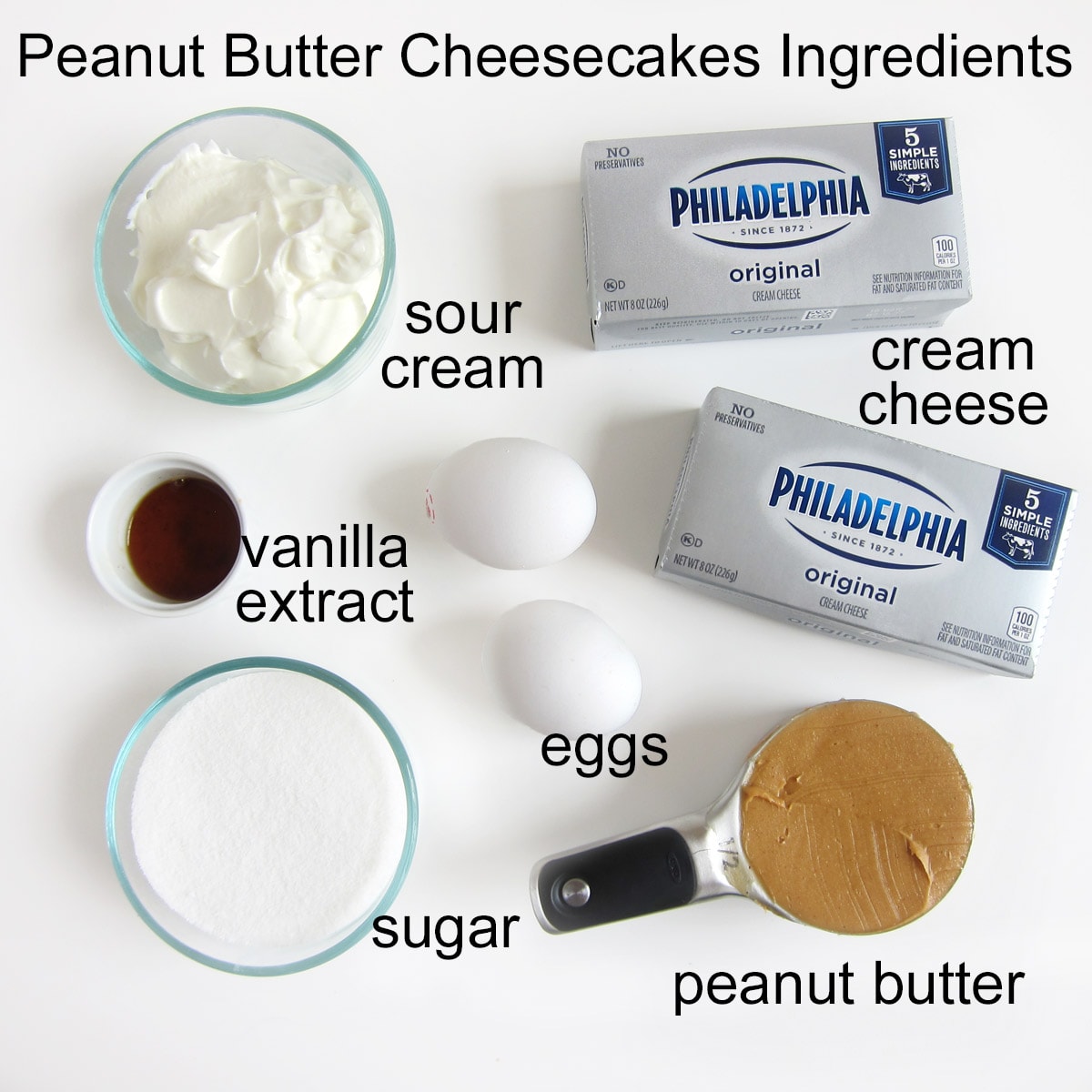 Peanut butter cheesecake ingredients including cream cheese, peanut butter, sugar, eggs, vanilla, and sour cream.