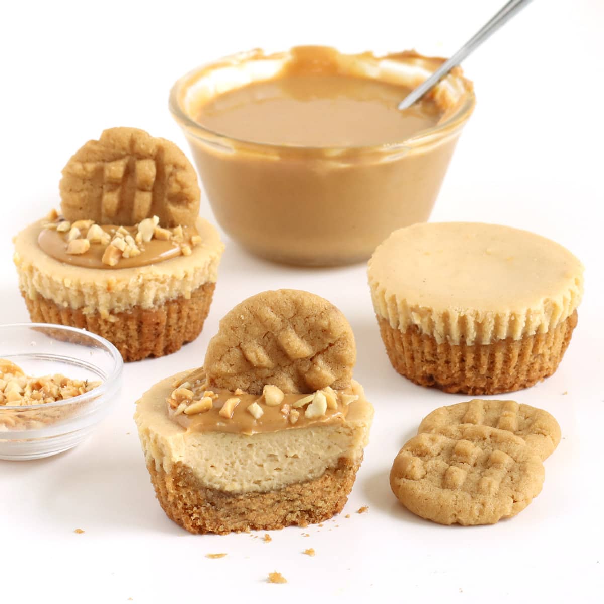 Peanut butter cheesecake cupcakes topped with creamy peanut butter, chopped peanuts, and mini peanut butter cookies.