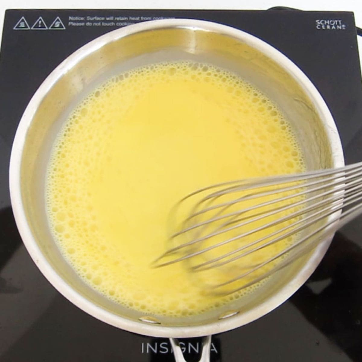 stirring the egg custard with a whisk in a skillet